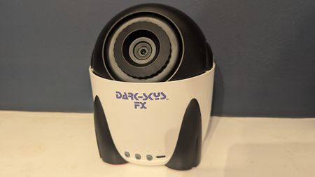 Dark Skys DS-FX Star Projector on a white shelf in front of a blue wall