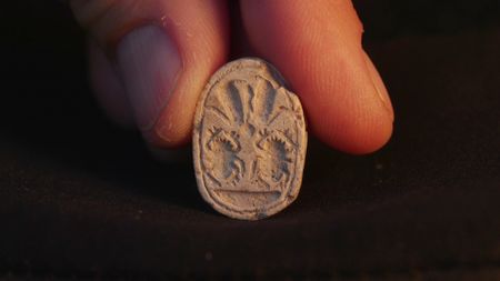 a closeup of an amulet with a scarab on it
