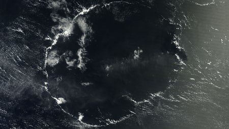 A satellite image of a thin wispy ring of clouds above the ocean